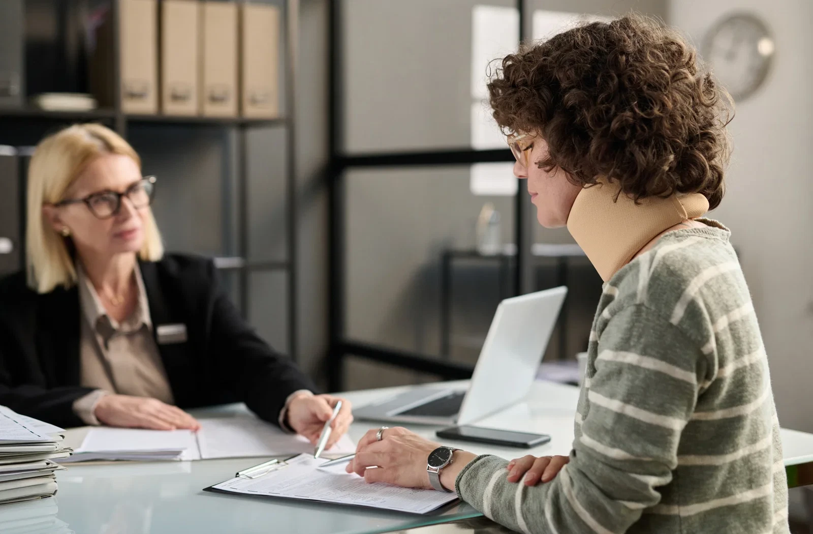 Young woman with neck injury filling documents